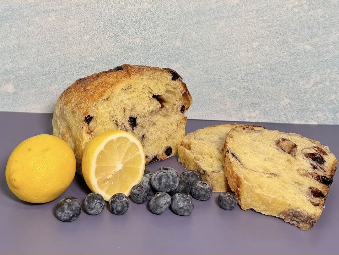 Lemon blueberry sourdough loaf sliced beside fresh berries